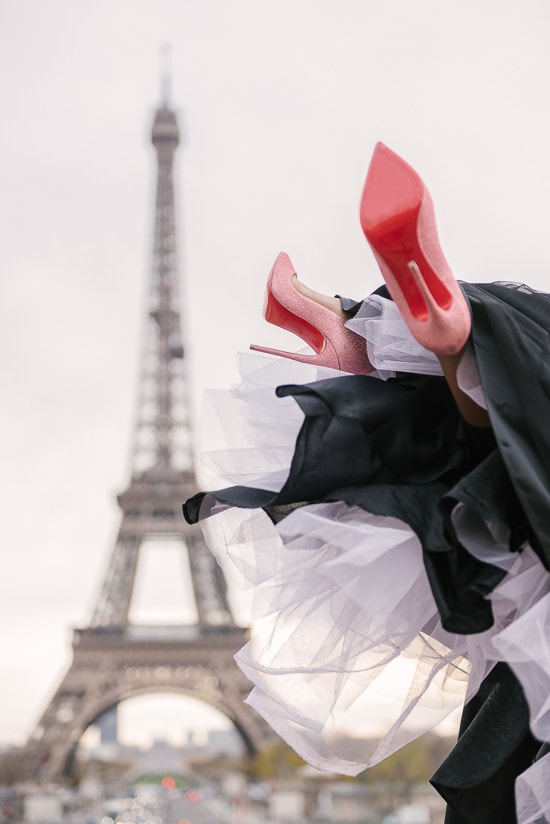 Christian Louboutin red soles lifted in the air at the Eiffel Tower in Paris Christian Louboutin red soles lifted in the air at the Eiffel Tower in Paris