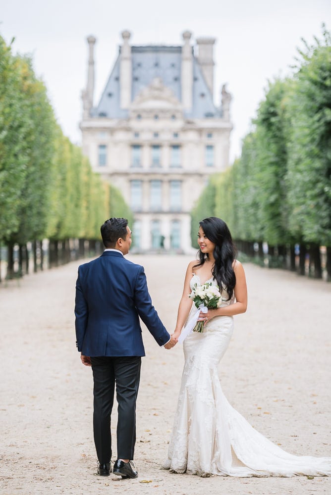 Elope to Paris in the Tuileries gardens. Bride and groom holding hands Elope to Paris in the Tuileries gardens. Bride and groom holding hands