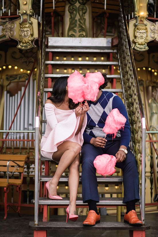 Girl with pink Louboutin heels kissing her boyfriend behind candy floss on the merry go round near Eiffel Tower Girl with pink Louboutin heels kissing her boyfriend behind candy floss on the merry go round near Eiffel Tower