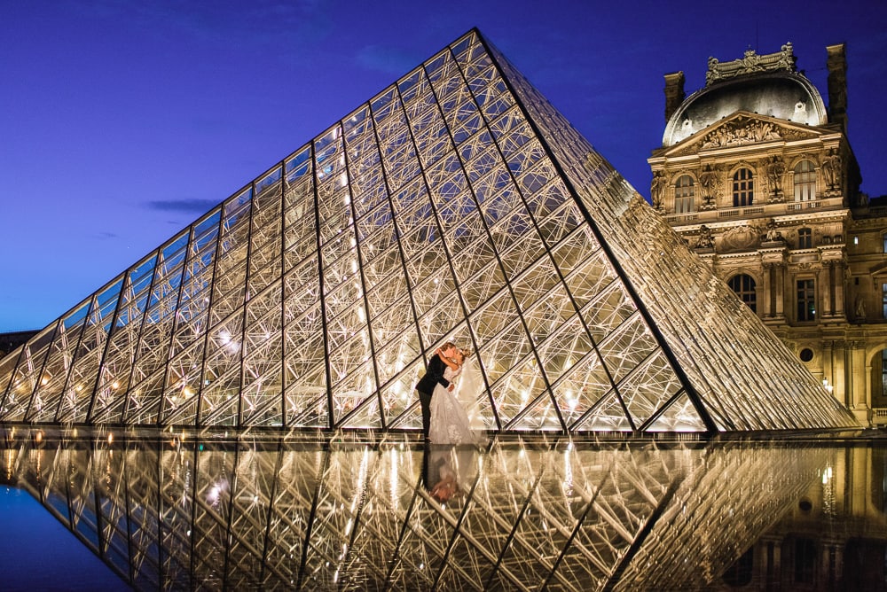 Paris elopement photographer - Creative reflection of bride and groom at the Louvre Museum Pyramid Paris elopement photographer - Creative reflection of bride and groom at the Louvre Museum Pyramid