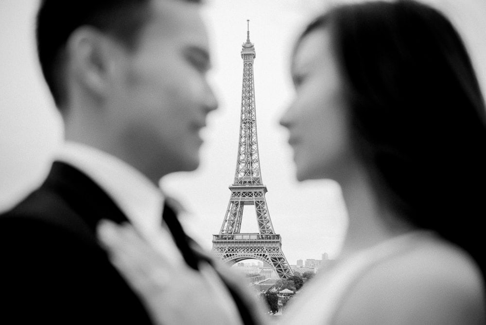 Paris pre wedding photo - Asian bride and groom looking at each other and Eiffel Tower shows in between Paris pre wedding photo - Asian bride and groom looking at each other and Eiffel Tower shows in between