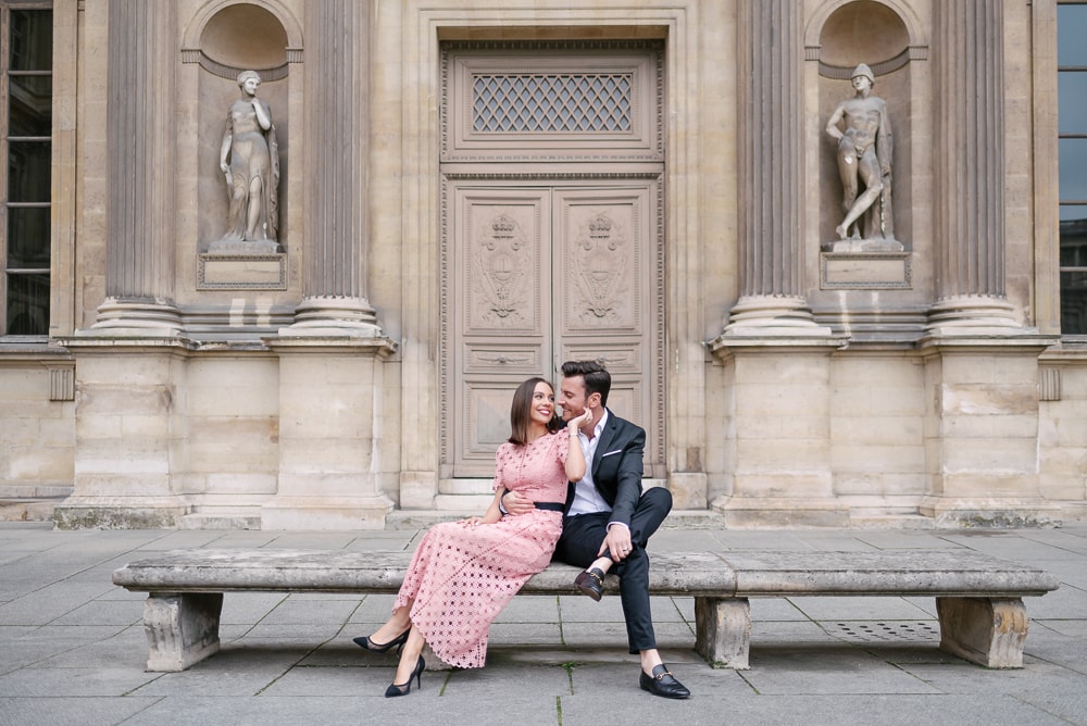 Engagement picture dresses - Girl in pink long dress being hugged by her fiancé in front of old door at the Louvre Museul in Paris Engagement picture dresses - Girl in pink long dress being hugged by her fiancé in front of old door at the Louvre Museul in Paris