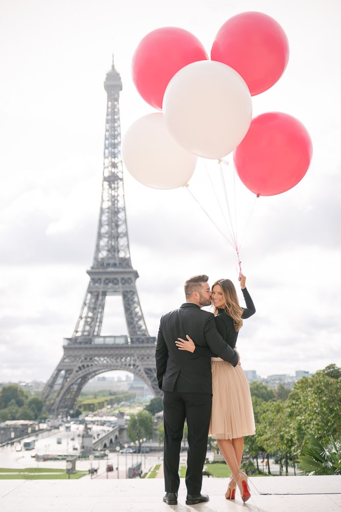 Gentleman kissing his fiancée on the cheek in front of the Eiffel Tower Gentleman kissing his fiancée on the cheek in front of the Eiffel Tower