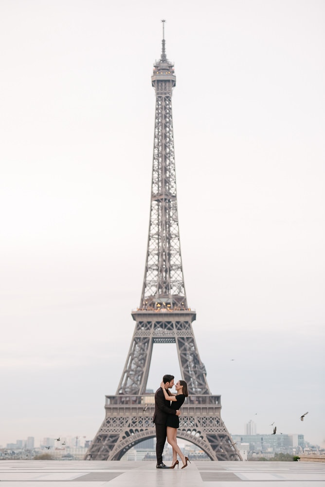 Picture ideas for couples - Iconic framing of a young couple in the middle of the Eiffel Tower Picture ideas for couples - Iconic framing of a young couple in the middle of the Eiffel Tower